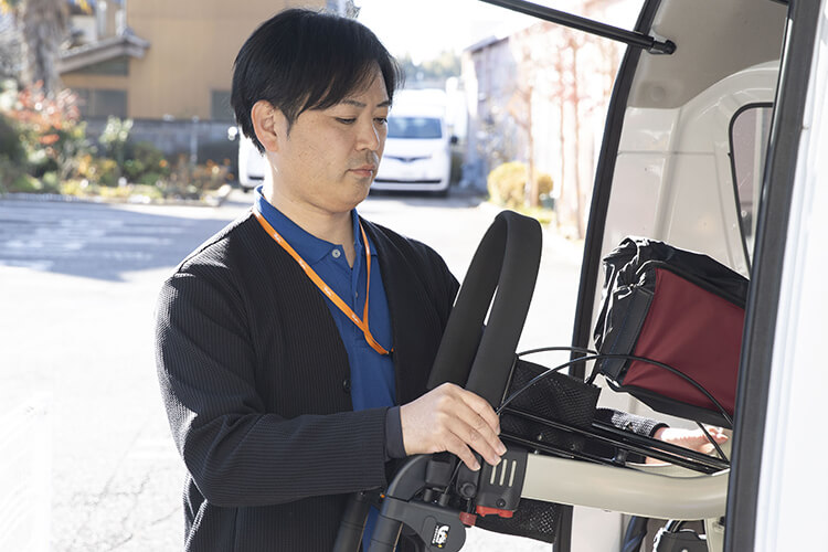 車に福祉用具を積み込む福祉用具専門相談員